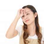雨の日に肩こりと頭痛に悩む女性をイメージした写真