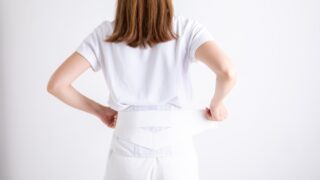 腰痛対策で骨盤矯正ベルトを装着する女性