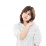 肩こりに悩む女性。秋バテによる体の不調や肩甲骨まわりの緊張を表している。