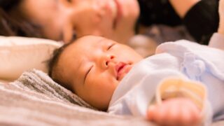 赤ちゃんと添い寝をするママ。