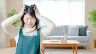 年末の忙しさに追われ、頭を抱える女性