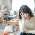 疲れ切って年末の大掃除ができずに困っている女性。