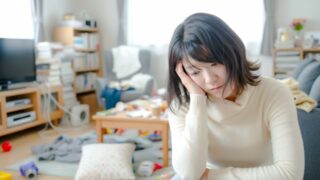 疲れ切って年末の大掃除ができずに困っている女性。