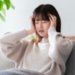 疲れ切って頭を抱える女性