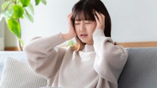 疲れ切って頭を抱える女性