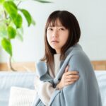 寒さで縮こまっている女性