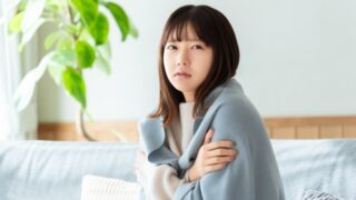 寒さで縮こまっている女性
