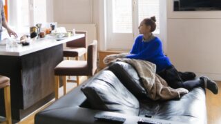 部屋で不良姿勢で座ってくつろぐ女性