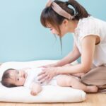 前かがみで育児をする女性