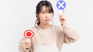 産後のNG習慣の説明のために、OKとNGプラカードを持つ女性