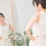 鏡を見て姿勢をチェックする笑顔の女性