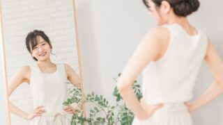 鏡を見て姿勢をチェックする笑顔の女性