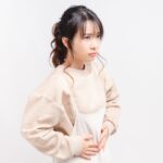 産後の恥骨痛で下腹部を押さえている女性