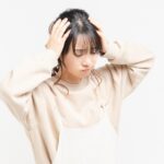 疲労で頭を抱える女性