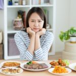 ダイエット中につい食べ過ぎてしまい悩んでいる女性