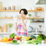 キッチンでカロリー計算する女性
