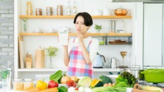 キッチンでカロリー計算する女性