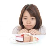 おやつを食べようか悩んでいる女性
