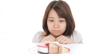 おやつを食べようか悩んでいる女性
